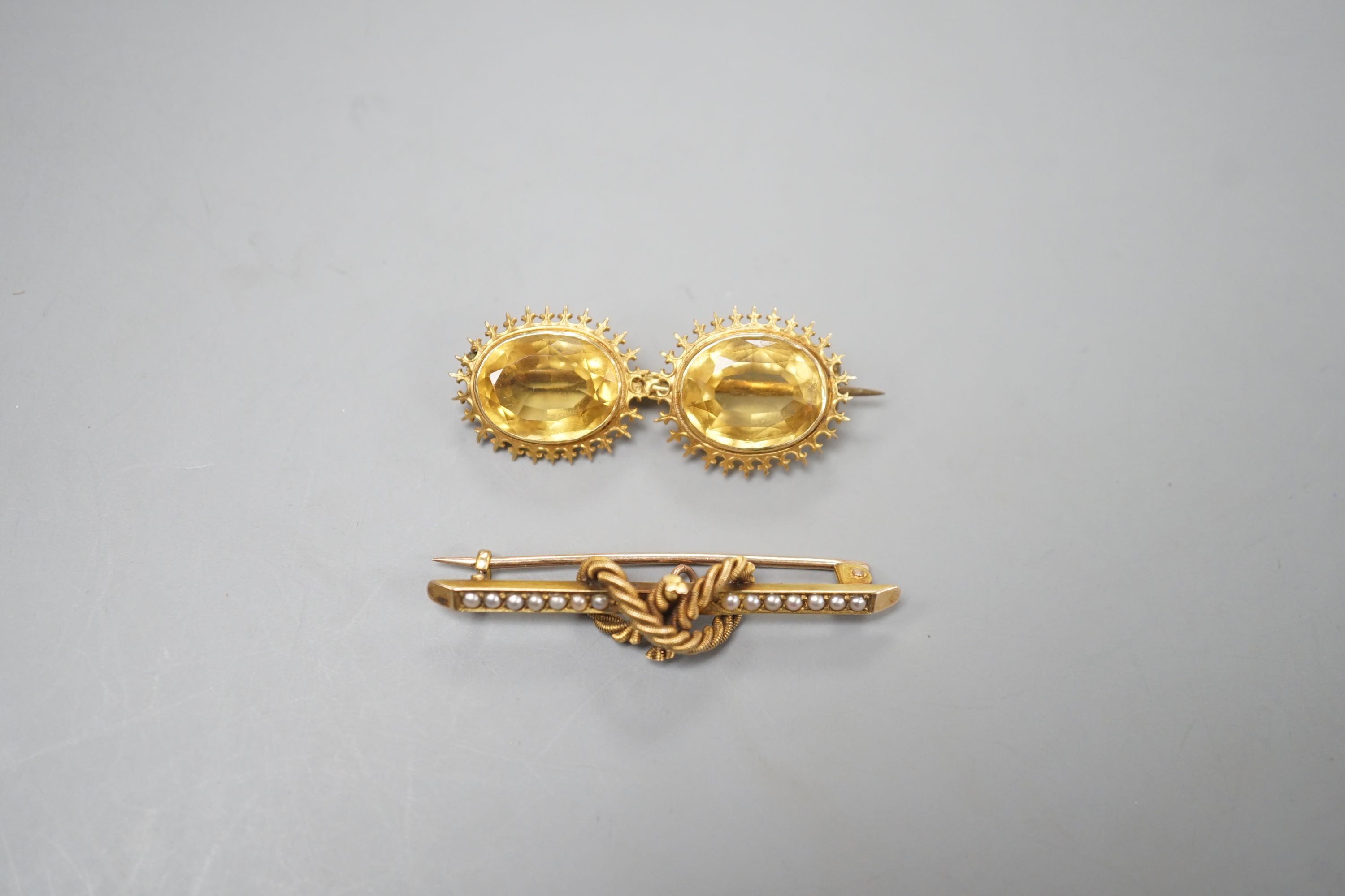 An Edwardian 15ct and seed pearl set rope twist bar brooch, 42mm and a yellow metal and two stone citrine set bar brooch, gross weight 8.3 grams.